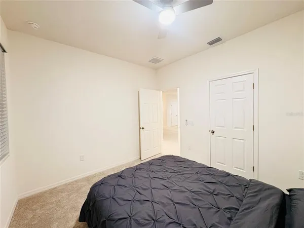 a bedroom with a bed and a fan