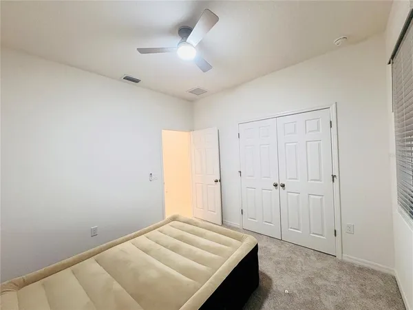 a bedroom with a bed and a ceiling fan