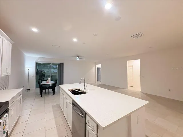 a kitchen with a sink and chairs