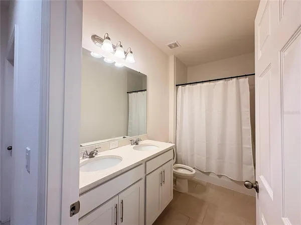 a bathroom with a double vanity sink and a mirror