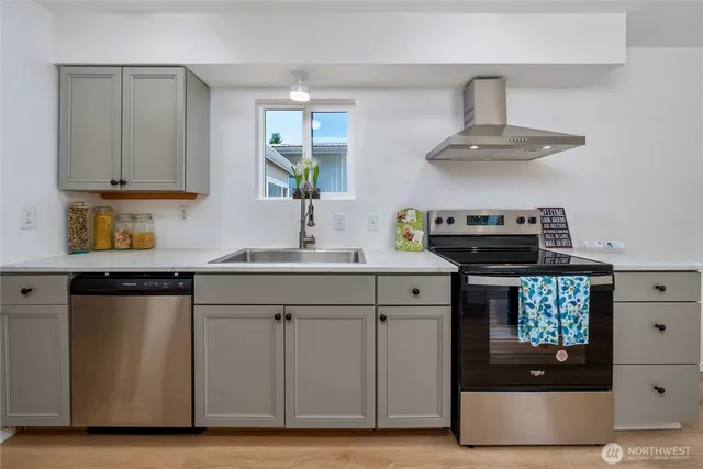 a kitchen with a sink a stove and cabinets