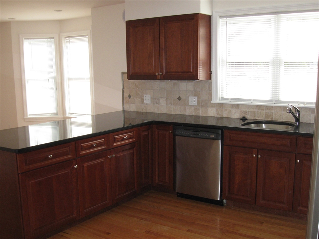 2856 Washington Street Boston, MA 02119 - Photo 31 of 39 a kitchen with granite countertop wooden cabinets and a granite counter tops