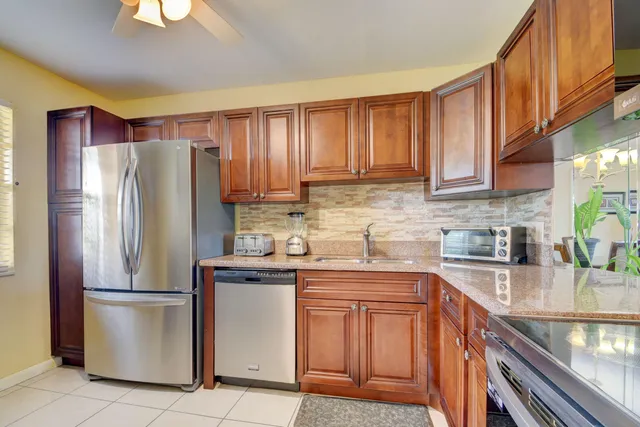 a kitchen with stainless steel appliances granite countertop a refrigerator sink and cabinets