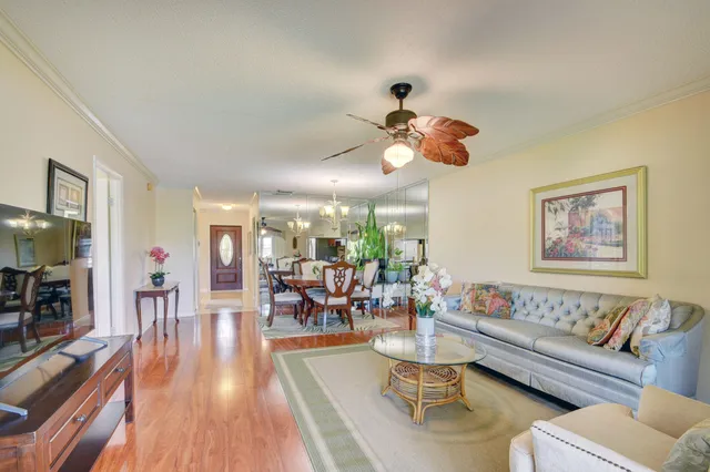 a living room with furniture kitchen view and a large window