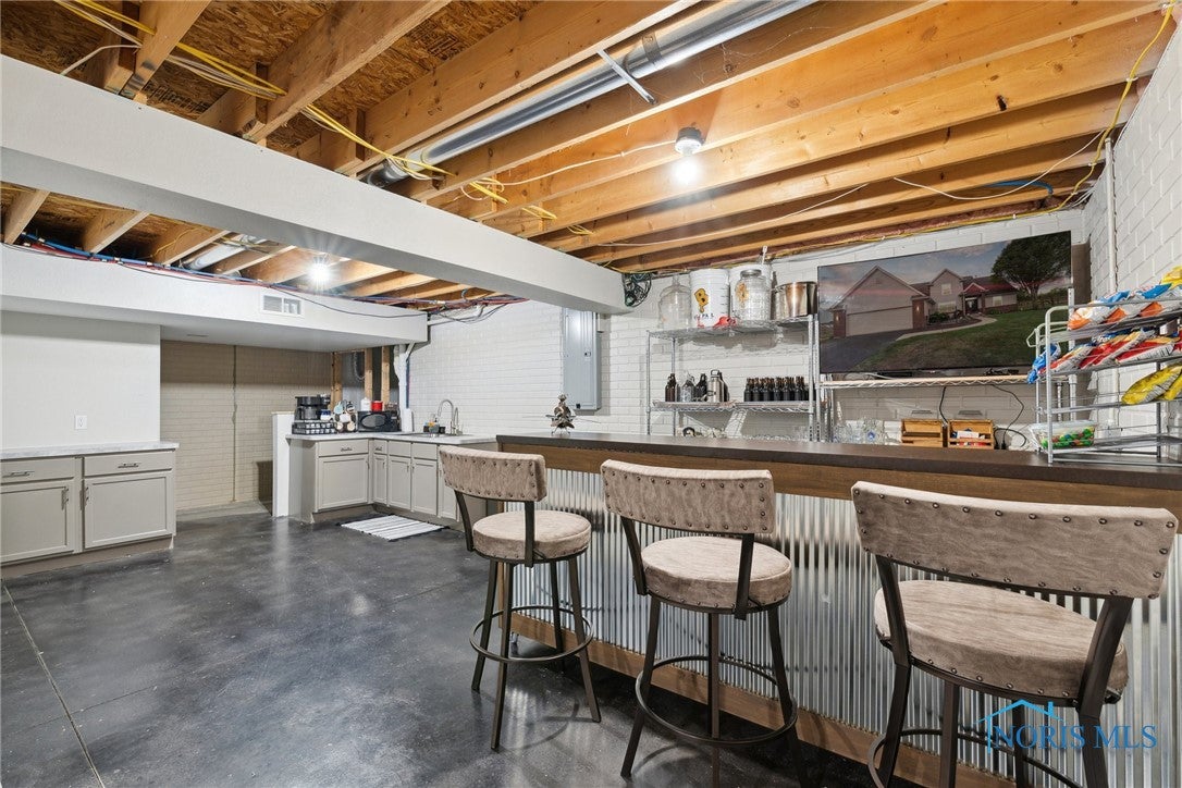 166 Lawai Road Oregon, OH 43616 - Photo 32 of 48 Bar and Kitchen area. New Lam tops, stained conrete floors, fridge.