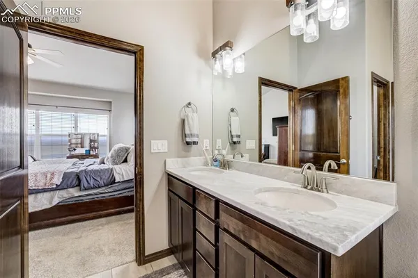 a en suite bathroom with a granite countertop sink and a mirror
