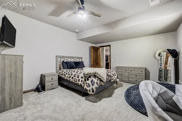 a bedroom with a bed flat screen tv and dresser