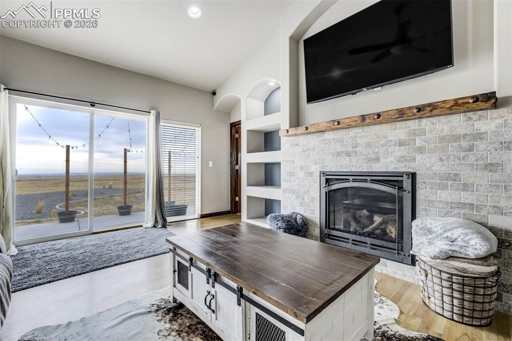 12095 Silver Concho Trail Elbert, CO 80106 - Photo 5 of 38 a living room with a fireplace a flat screen tv and view kitchen
