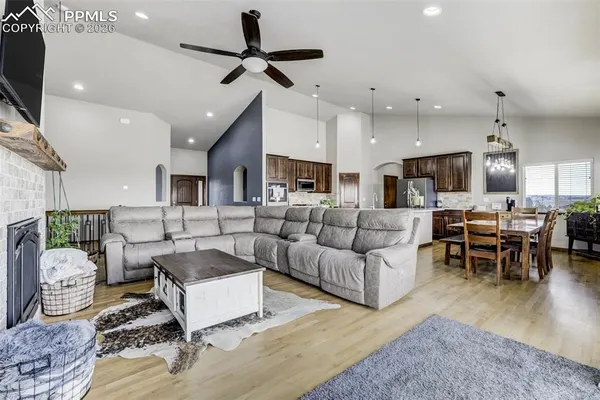 a living room with furniture kitchen view and a chandelier