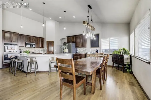 a kitchen with stainless steel appliances kitchen island granite countertop a dining table chairs and view living room