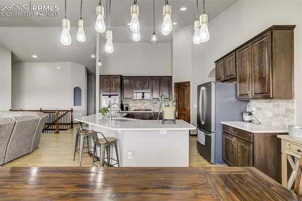 a kitchen with stainless steel appliances granite countertop a sink a stove and kitchen island