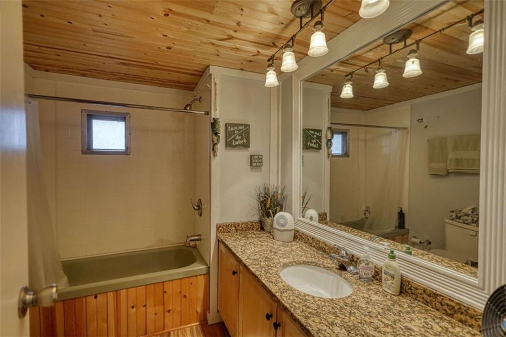 123 Copper Lane Mansfield, GA 30055 - Photo 26 of 43 a bathroom with a granite countertop sink a mirror a bathtub and shower