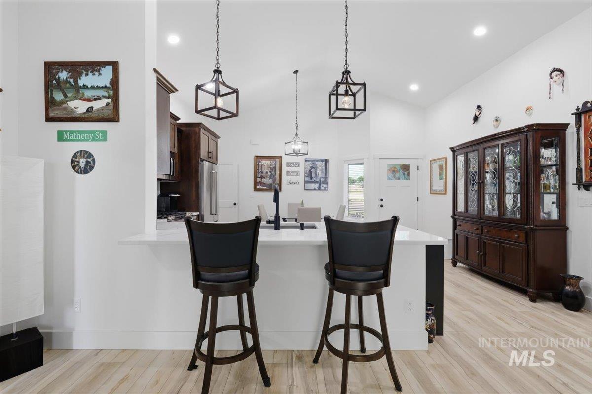918 Sierra Street Vale, OR 97918 - Photo 12 of 42 Kitchen island with white countertop, recessed lighting, wood-finish flooring, dark wood cabinetry, and stainless steel appliances