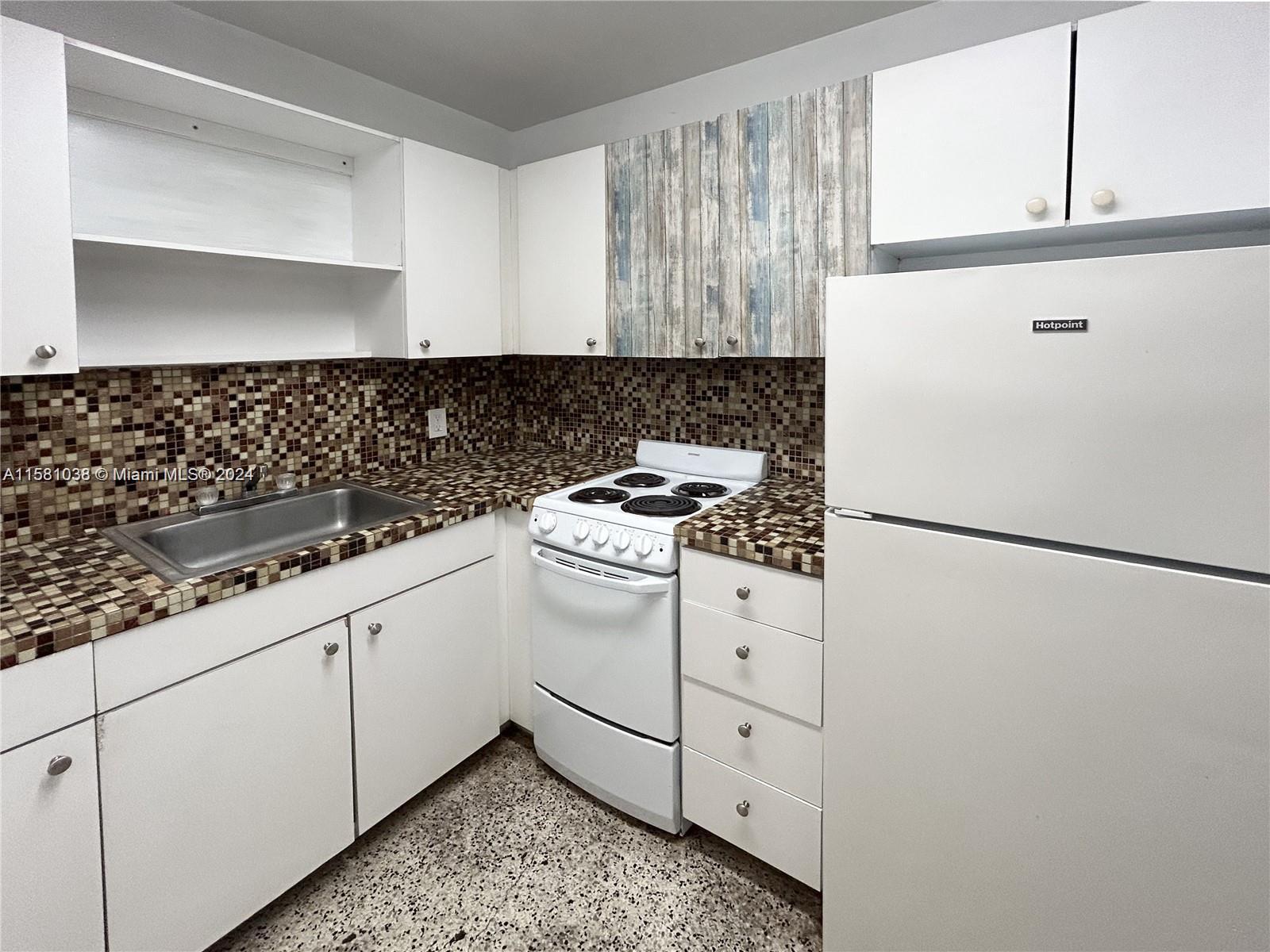 a kitchen with white cabinets and white appliances
