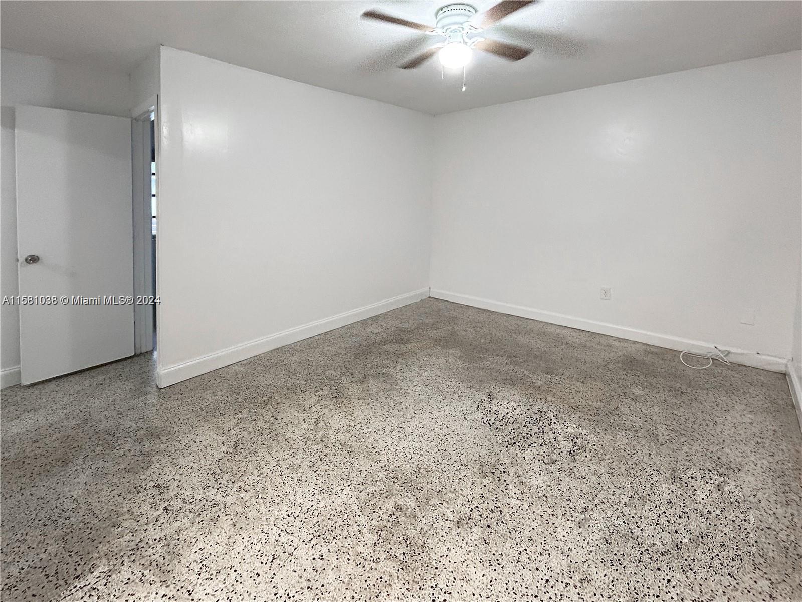 699 Northeast 86th Street, Unit 2 Miami, FL 33138 - Photo 3 of 12 an empty room with a chandelier fan