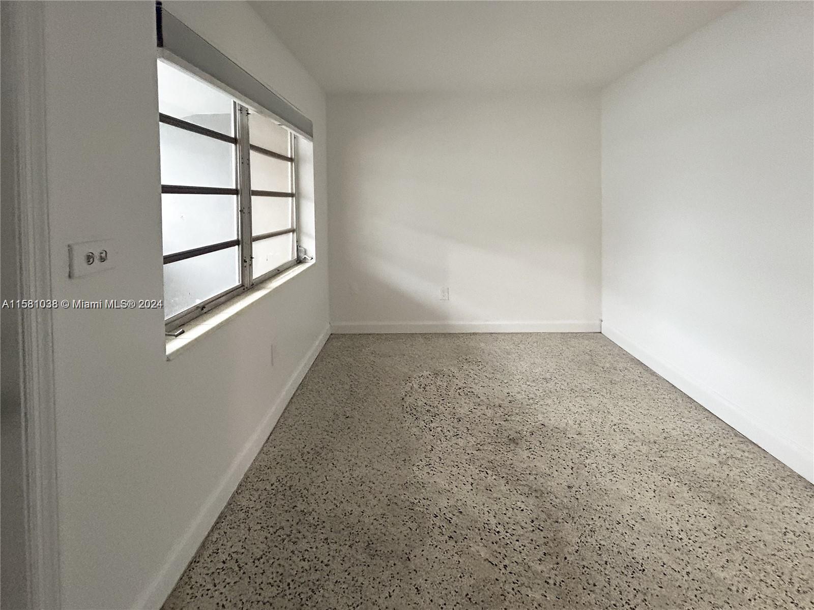 699 Northeast 86th Street, Unit 2 Miami, FL 33138 - Photo 5 of 12 an empty room with a empty space and window