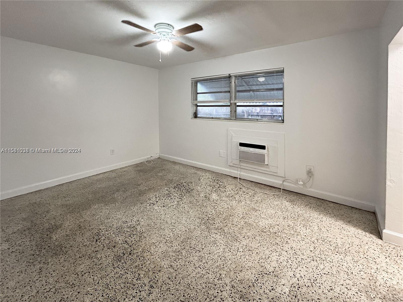 699 Northeast 86th Street, Unit 2 Miami, FL 33138 - Photo 7 of 12 an empty room with windows and ceiling fan
