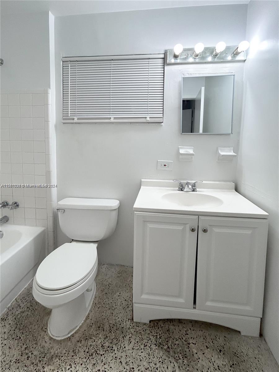 699 Northeast 86th Street, Unit 2 Miami, FL 33138 - Photo 10 of 12 a bathroom with a sink toilet a mirror and bathtub