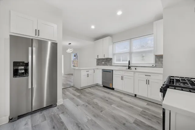 a kitchen with white cabinets and white appliances