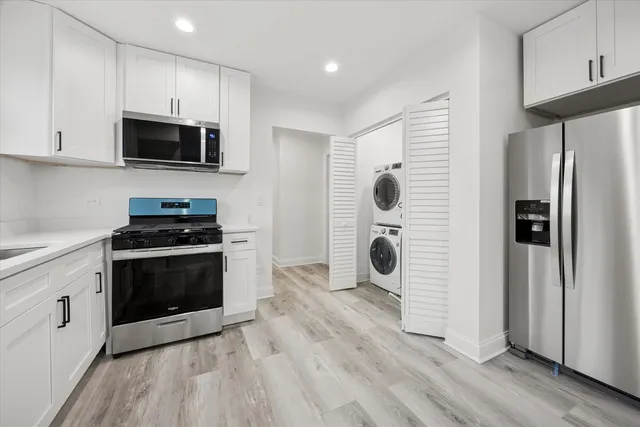 a kitchen with stainless steel appliances a stove a microwave and a hard wood floors