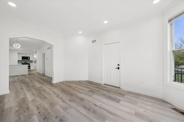 a view of a big room with wooden floor and windows