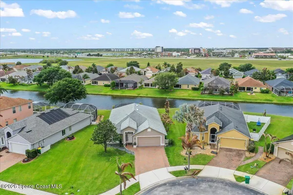 an aerial view of a house with a garden and lake view
