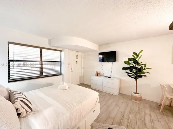 a bedroom with a bed and a flat screen tv