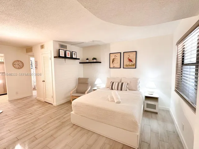 a bedroom with a bed and a large window