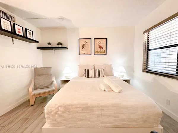 a bedroom with a bed a mirror and a window