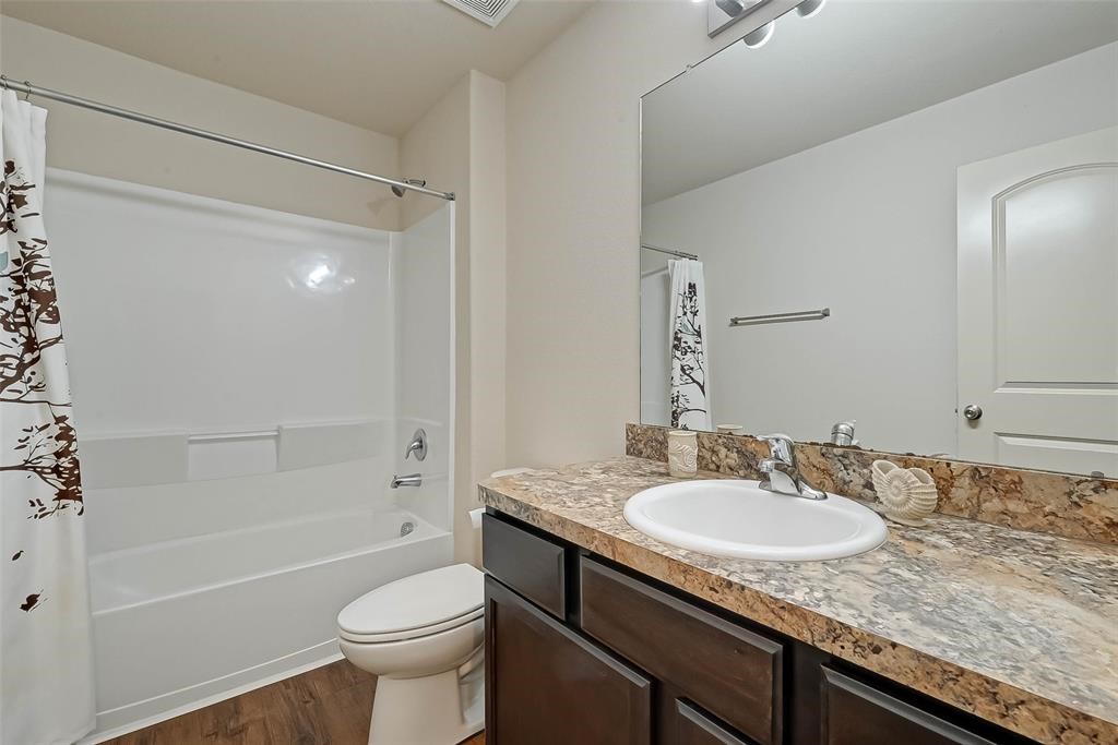 1415 Rodeo Cattle Lane Houston, TX 77049 - Photo 16 of 18 a bathroom with a granite countertop sink toilet and shower