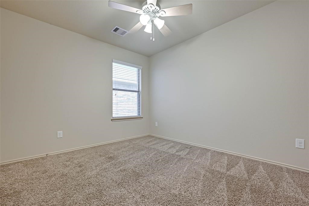 1415 Rodeo Cattle Lane Houston, TX 77049 - Photo 17 of 18 an empty room with a chandelier fan and windows
