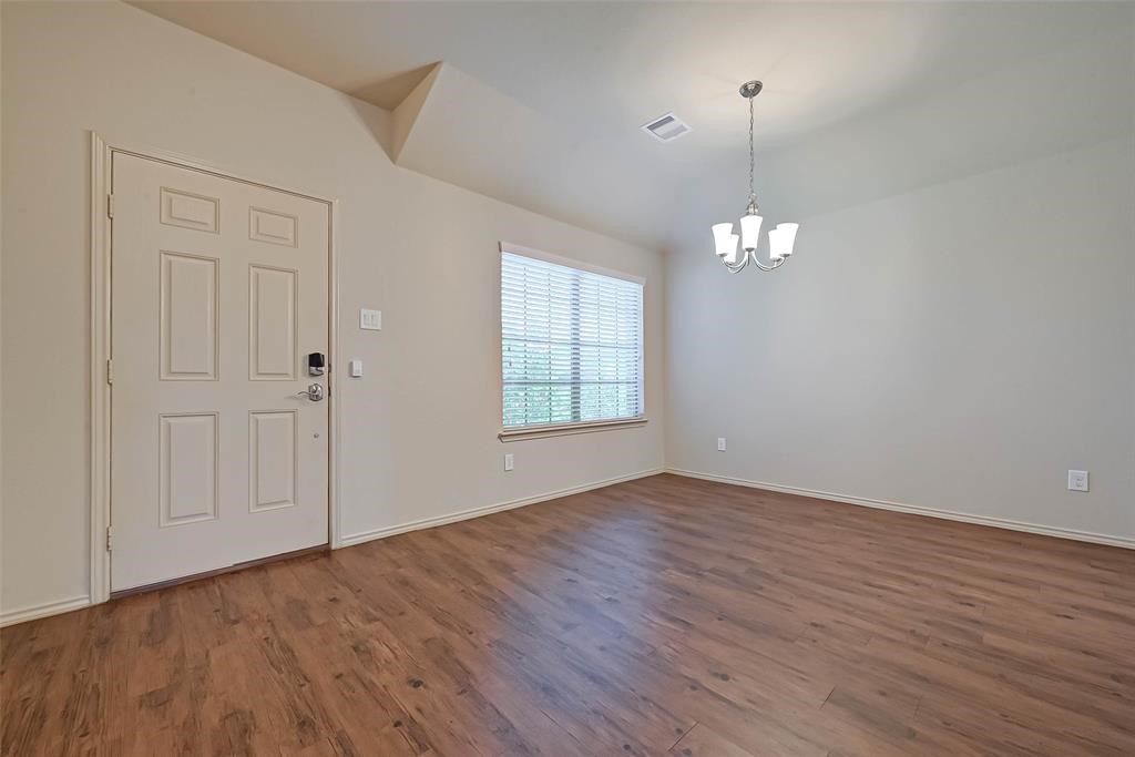 1415 Rodeo Cattle Lane Houston, TX 77049 - Photo 3 of 18 an empty room with wooden floor chandelier and window