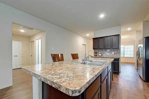 a kitchen with kitchen island granite countertop wooden floor and center island