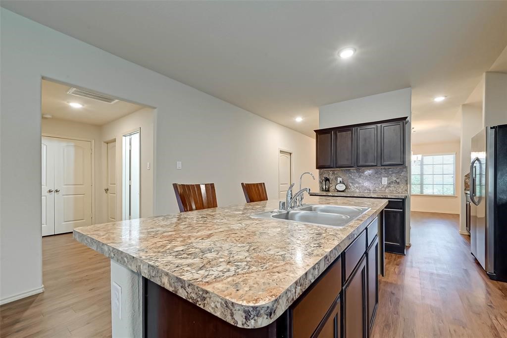 1415 Rodeo Cattle Lane Houston, TX 77049 - Photo 8 of 18 a kitchen with kitchen island granite countertop wooden floor and center island