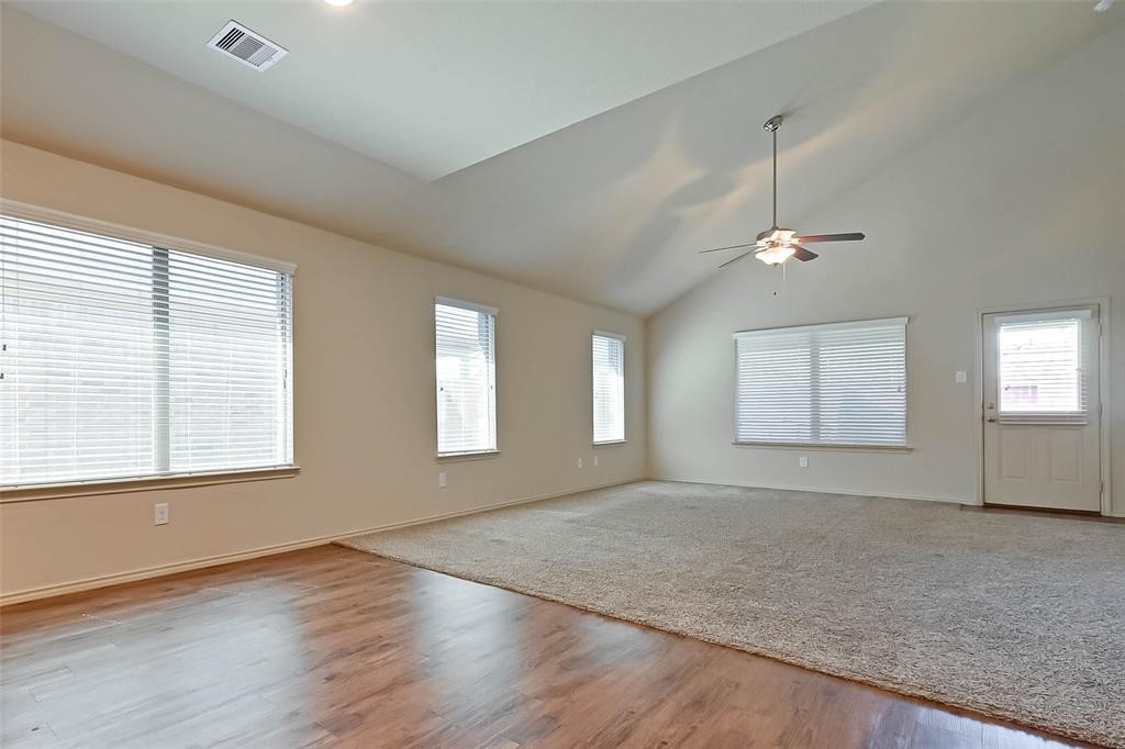 1415 Rodeo Cattle Lane Houston, TX 77049 - Photo 10 of 18 an empty room with chandelier fan and windows