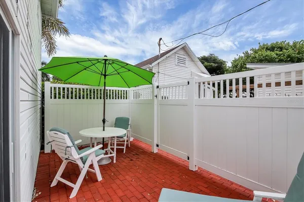 a view of a patio with a table and chairs under an umbrella