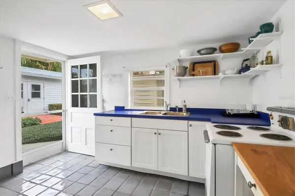 a kitchen with granite countertop white cabinets and white appliances