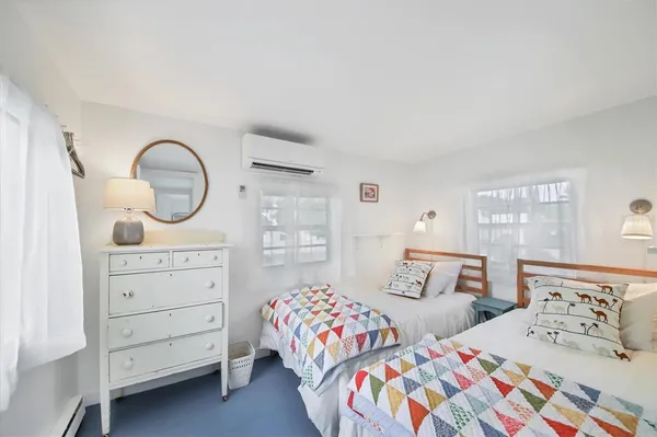 a bedroom with two beds and a dresser