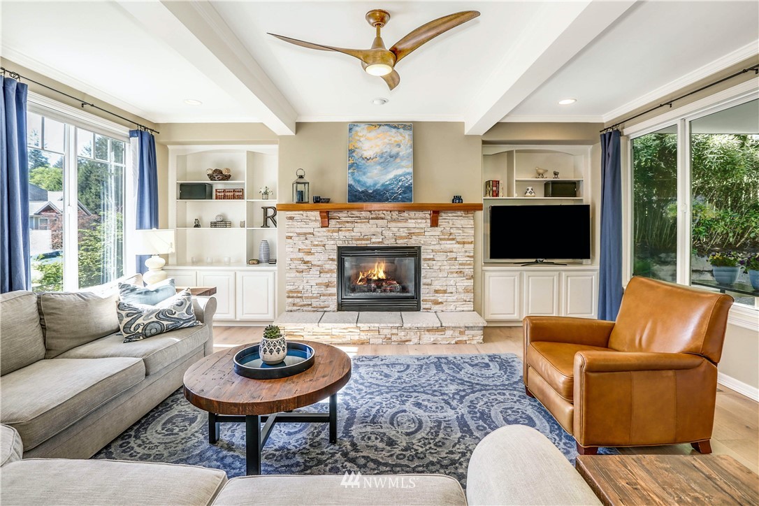 17124 Southeast 100th Street Renton, WA 98059 - Photo 12 of 40 a living room with furniture a fireplace and a floor to ceiling window