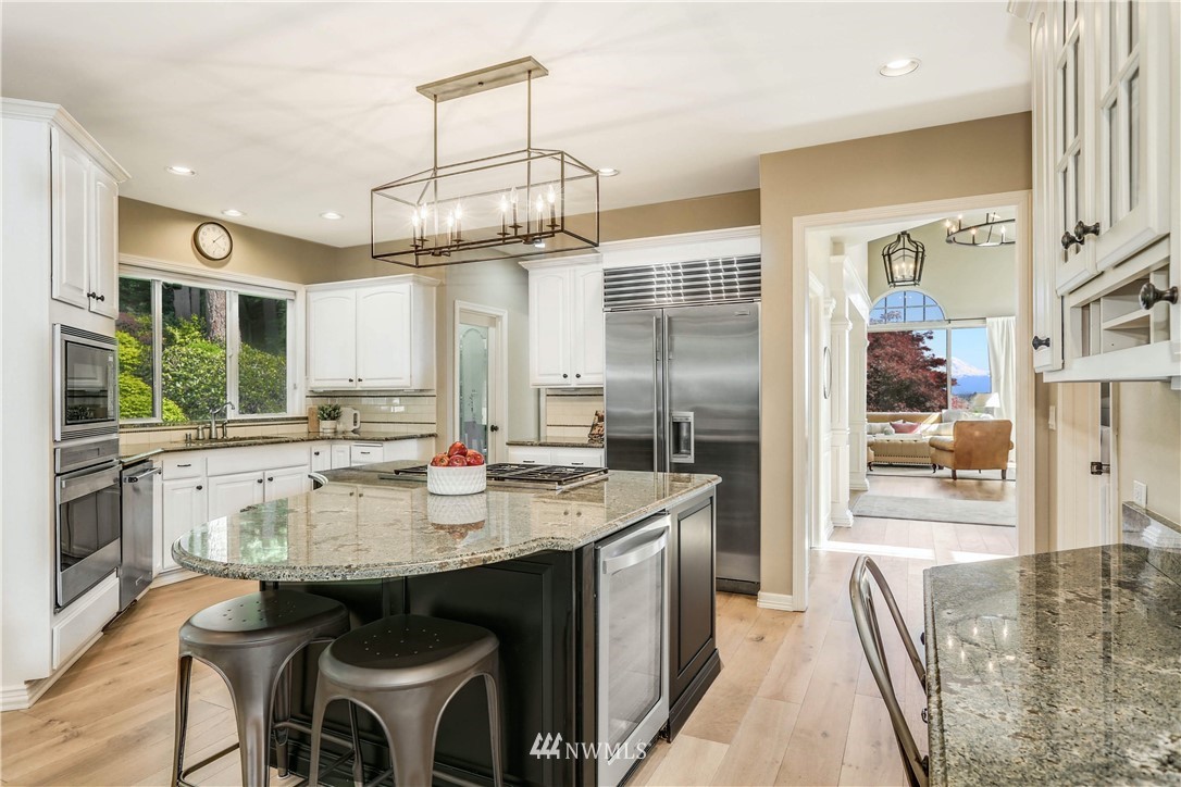 17124 Southeast 100th Street Renton, WA 98059 - Photo 8 of 40 a kitchen with granite countertop a sink and a refrigerator