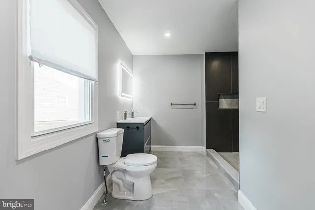a white toilet sitting next to a bathroom sink