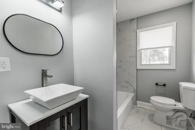 a bathroom with a toilet a sink and mirror