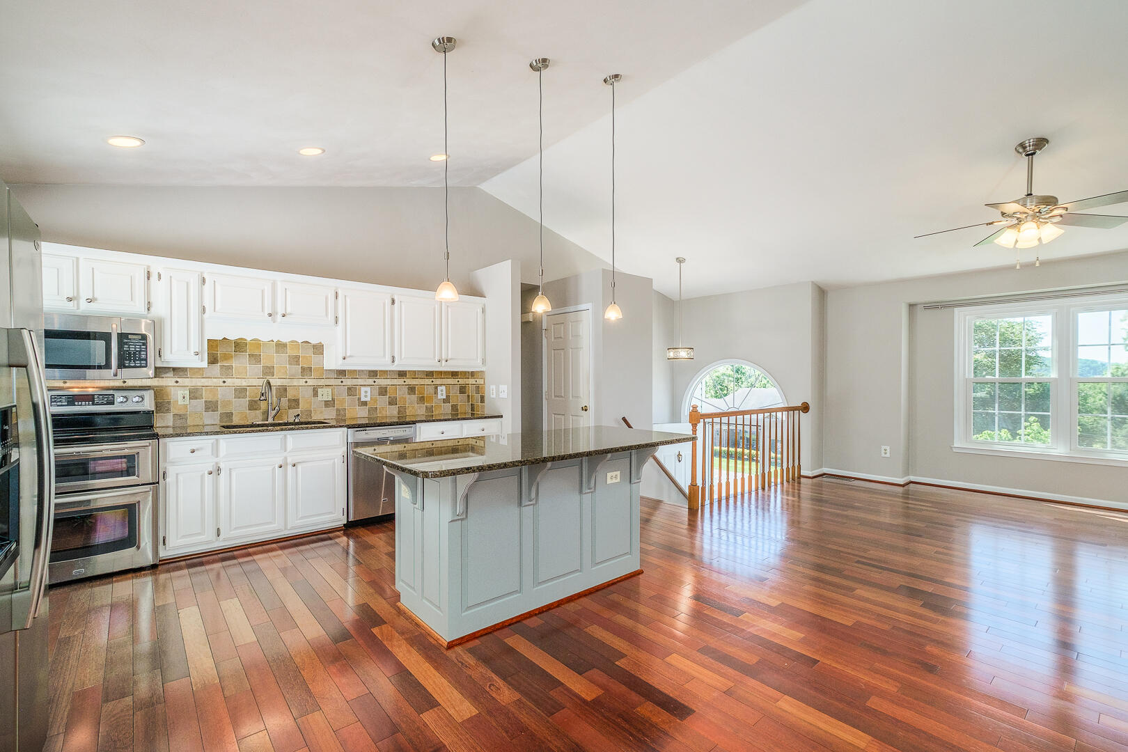 5443 Setter Road Roanoke, VA 24012 - Photo 10 of 42 a kitchen with stainless steel appliances kitchen island wooden floors stove and white cabinets