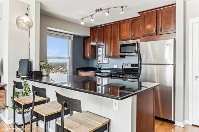 a kitchen with stainless steel appliances granite countertop wooden cabinets a stove top oven a sink and dishwasher