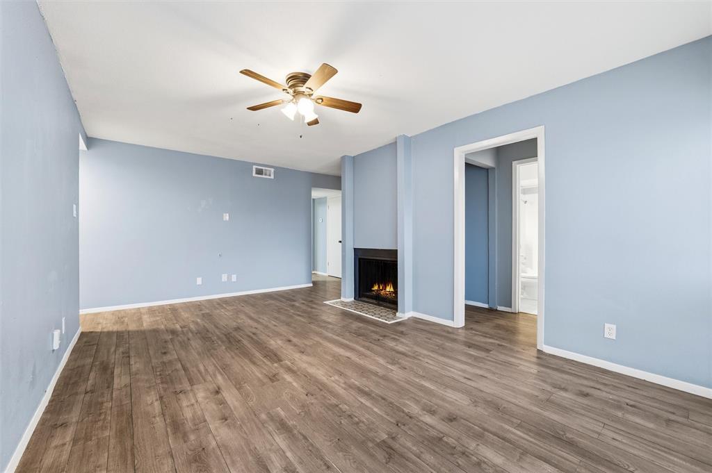 5604 Boca Raton Boulevard, Unit 248 Fort Worth, TX 76112 - Photo 5 of 25 a view of an empty room with wooden floor and a ceiling fan