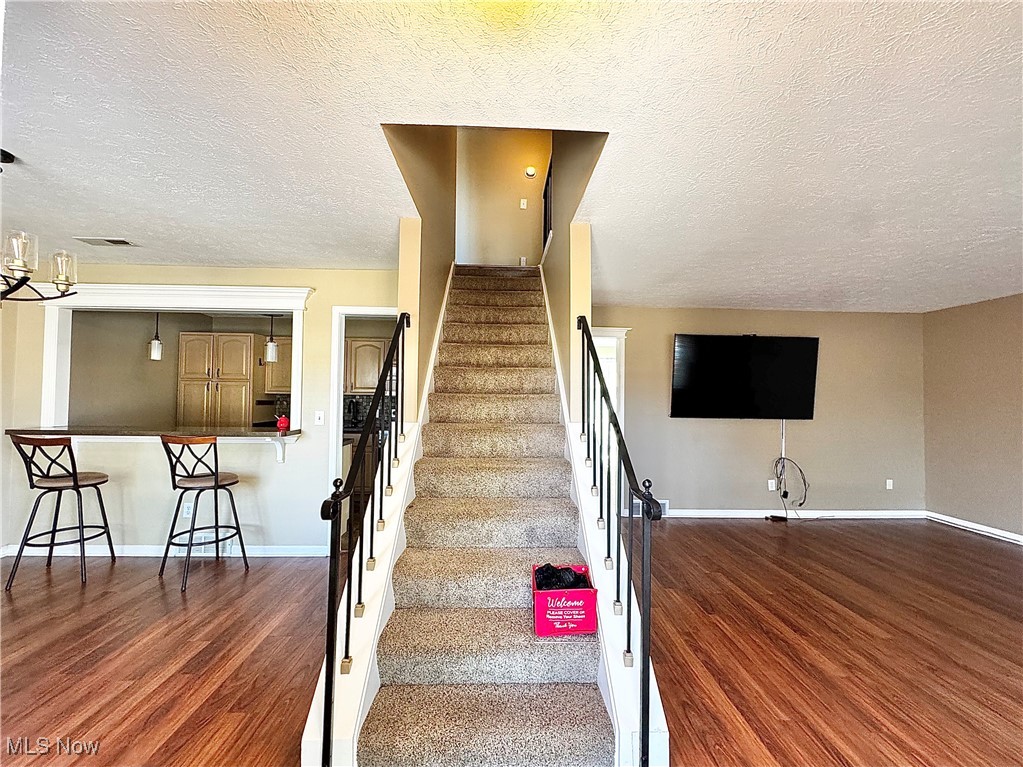 7050 Chillicothe Road, Unit B18 Mentor, OH 44060 - Photo 13 of 24 Stairs with a textured ceiling and wood finished floors