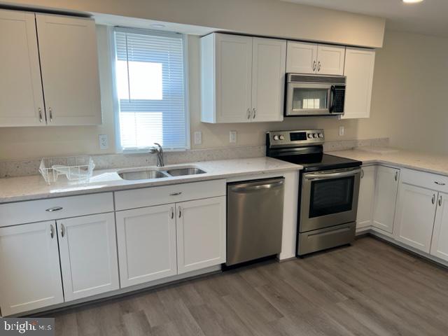 17207 Manning Drive Accokeek, MD 20607 - Photo 4 of 18 a kitchen with white cabinets appliances a sink and a window