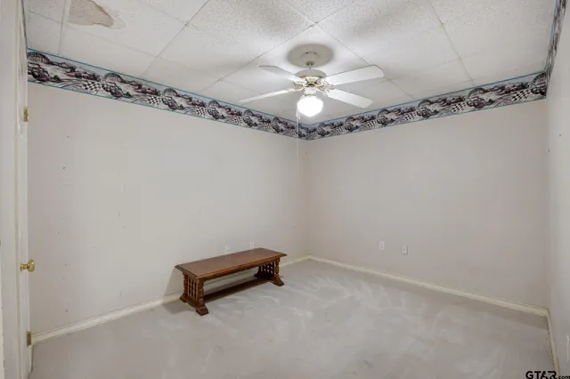 a room with a hanging light and hardwood floor