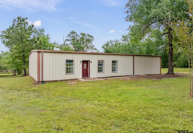 a backyard of a house with plants and wooden fence