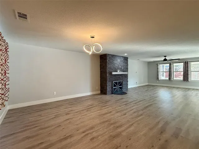 an empty room with wooden floor and window